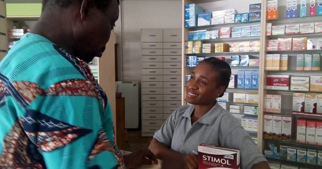 Une vendeuse en pharmacie servant un client